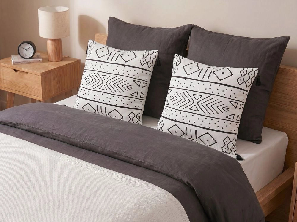 Set di 2 cuscini motivo geometrico nappe 45 x 45cm bianco e nero