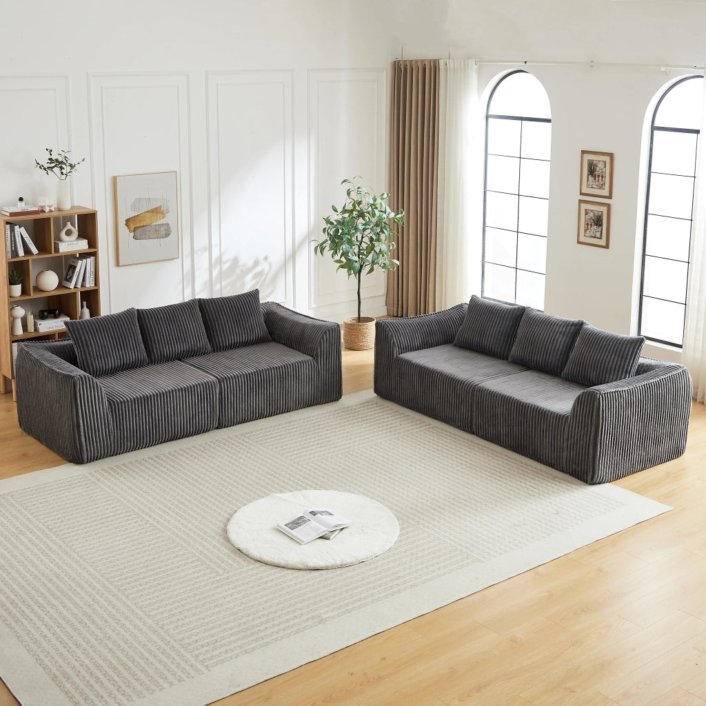 Divano modulare in velluto a coste con linee curve e cuscini in tessuto grigio